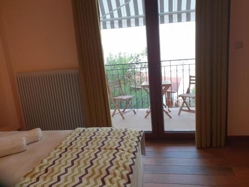 a bedroom with a bed and a balcony with a table at Mondeus Inn Luxury in Deskáti