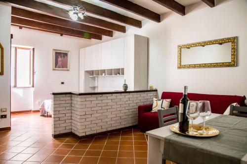 a living room with a red couch and a table with wine glasses at Casa Vacanze da Angela in Alghero