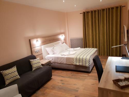 a hotel room with a bed and a couch at Mondeus Inn Luxury in Deskáti