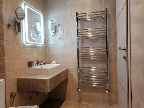 a bathroom with a sink and a mirror at Mondeus Inn Luxury in Deskáti