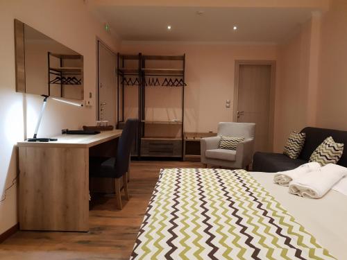 a bedroom with a bed and a desk and a kitchen at Mondeus Inn Luxury in Deskáti