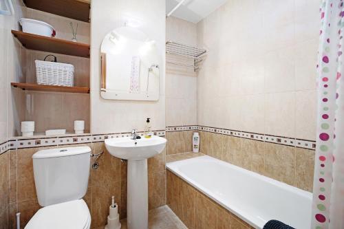 a bathroom with a toilet and a sink and a bath tub at Casa Milagros in Sanlúcar de Barrameda