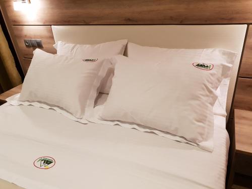 a bed with white pillows on top of it at Mondeus Inn Luxury in Deskáti