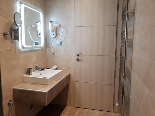 a bathroom with a sink and a shower at Mondeus Inn Luxury in Deskáti