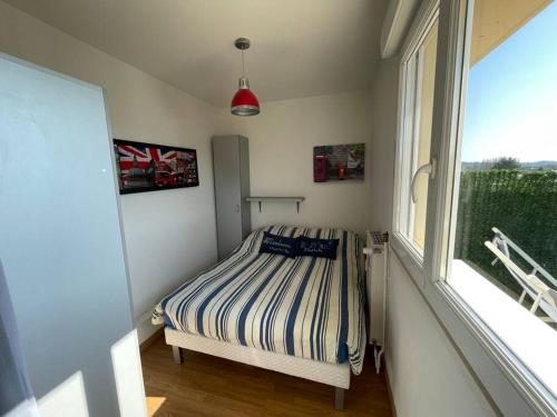 a small bedroom with a bed and a window at Appartement chaleureux , cosy, bien équipé et bien placé in Sedan