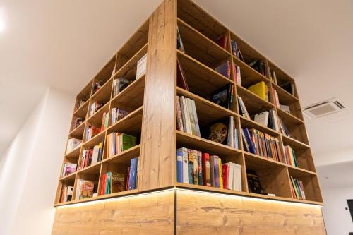 a book shelf filled with books in a room at Self-Check-in Hotel VinoQ Zistersdorf in Zistersdorf