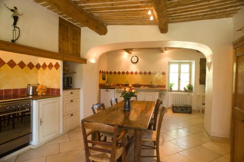a kitchen with a wooden table in a room at Gîtes Domaine des Machottes in Grans