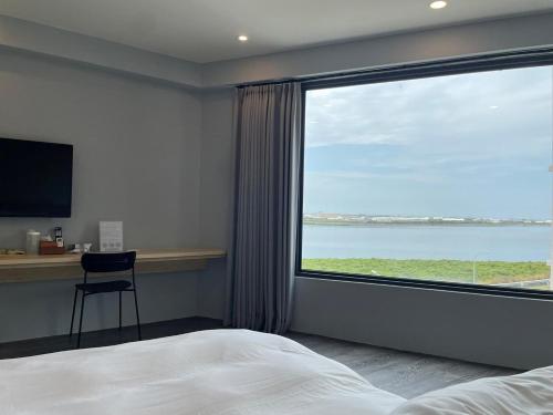 um quarto com uma grande janela com vista para o oceano em H Suite Sea em Lukang