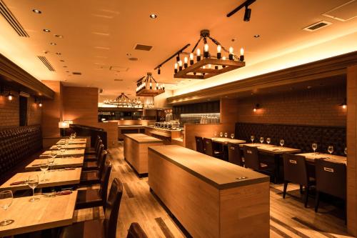 a restaurant with wooden tables and chairs and lights at Osaka Tokyu REI Hotel in Osaka