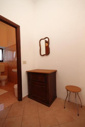 a bathroom with a vanity and a stool and a mirror at Apartment Basanija 7149c in Savudrija