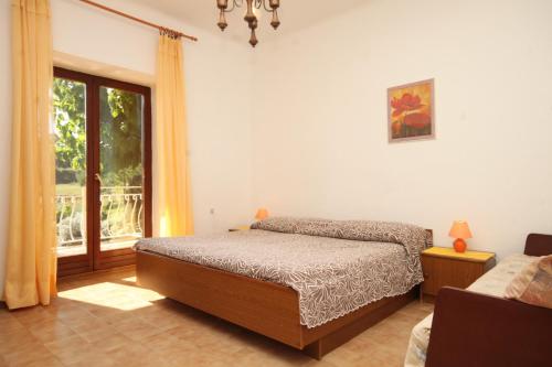 a bedroom with a bed and a window at Apartment Basanija 7149b in Savudrija