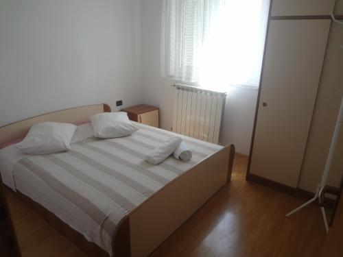 een slaapkamer met een bed met 2 kussens erop bij Apartment Valica 7122c in Umag