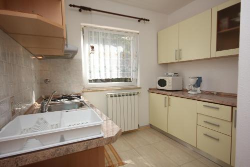 een keuken met een wastafel en een raam bij Apartment Valica 7122c in Umag