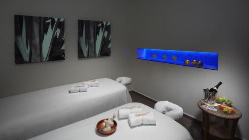 a room with two beds and a table with food on it at The Inbal Jerusalem in Jerusalem