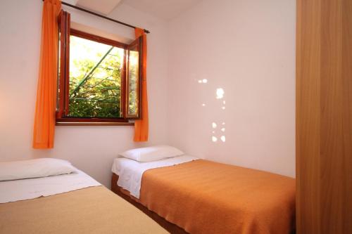 1 dormitorio con 2 camas y ventana en Apartments with a parking space Fazana - 7153 en Fažana