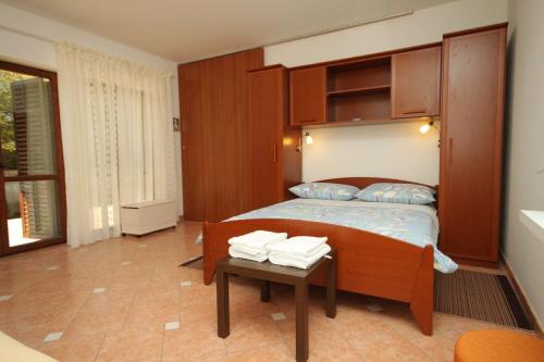- une chambre avec un lit et une table avec des serviettes dans l'établissement Family friendly apartments with a swimming pool Lindar, Central Istria - Sredisnja Istra - 7197, à Pazin