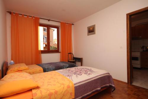 a bedroom with two beds and a window at Apartment Fazana 7153b in Fažana