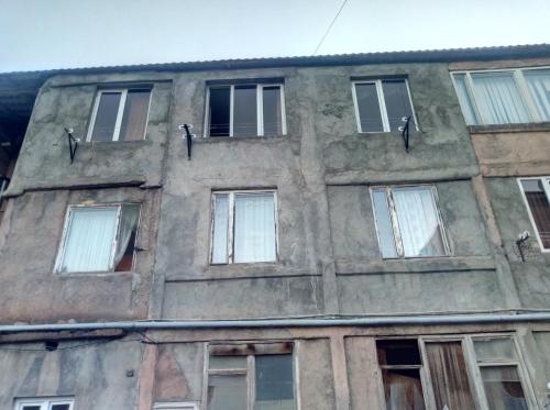 un edificio antiguo con ventanas laterales en Tsovella House, en Jermuk