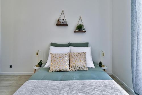 Schlafzimmer mit einem Bett mit weißen Wänden in der Unterkunft Appartement Cosy Bourgoin - Gare & Centre in Bourgoin