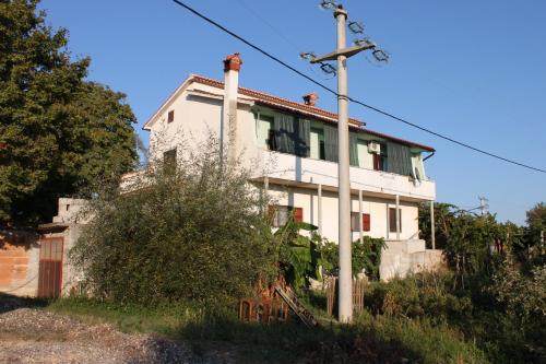 a white house with a pole in front of it at Apartments with parking space Gracisce, Central Istria - Sredisnja Istra - 7134 in Gračišće
