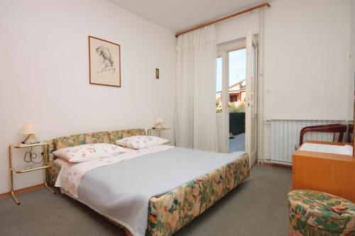 a hotel room with a bed and a chair at Apartments with a parking space Novigrad - 7121 in Novigrad Istria