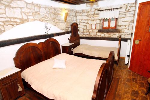 a bedroom with two beds and a stone wall at Family friendly house with a swimming pool Sveti Petar u Sumi, Central Istria - Sredisnja Istra - 7092 in Sveti Petar u Šumi