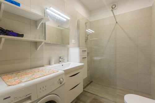 a white bathroom with a sink and a shower at Apartments with a parking space Kukci, Porec - 7166 in Nova Vas