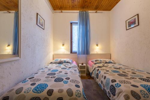 two twin beds in a room with a window at Apartments with a parking space Kukci, Porec - 7166 in Nova Vas