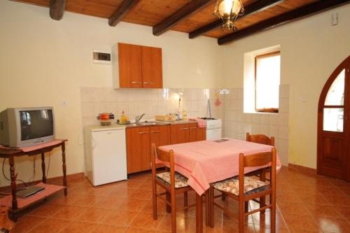 a kitchen with a table and a tv in a room at Apartments with a parking space Heraki, Central Istria - Sredisnja Istra - 7167 in Stifanići