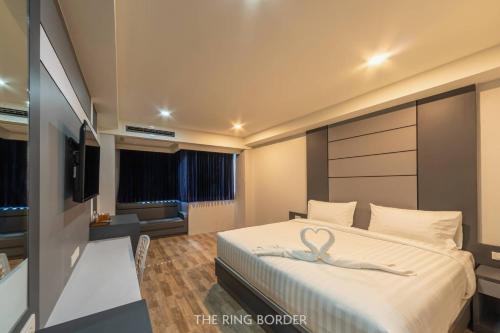 a hotel room with a bed with a ribbon on it at The Ring Border in Ban Khlong Phruan