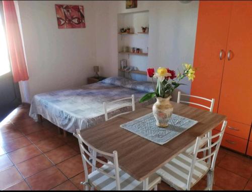 アルツァケーナにあるMonolocale in Costa Smeraldaのテーブル付きの部屋、ベッド付きのベッドルーム1室が備わります。