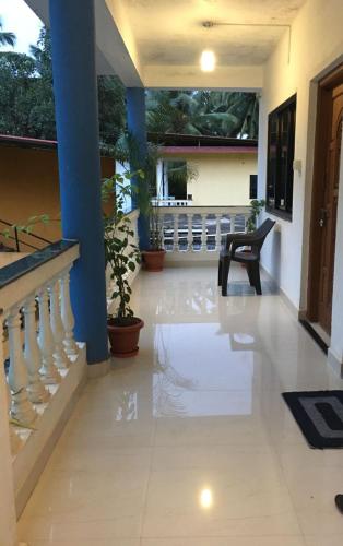 a hallway of a house with a staircase and a chair at Palolem Sunrise Apartment in Palolem