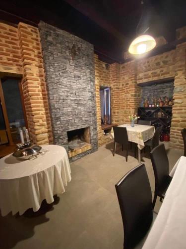 a dining room with two tables and a fireplace at Dzveli Ubani in Sighnaghi