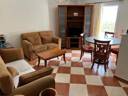 Morning Star Guesthouse في شرم الشيخ: غرفة معيشة مع أريكة وطاولة