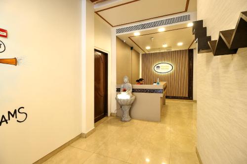 a lobby of a hotel with a counter with a statue at Hotel Mumbai House Juhu, Santacruz West, Mumbai in Mumbai