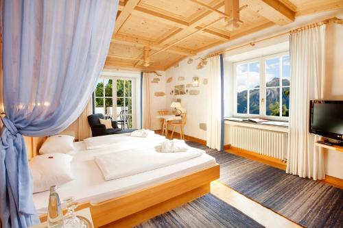 a bedroom with a large bed and a tv at Hotel Hirsch in Füssen