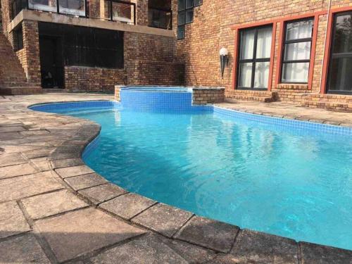 a swimming pool with blue water in front of a building at The Haven in Nelspruit