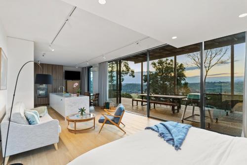 a bedroom with a bed and a living room at Byron Hinterland Villas in Clunes