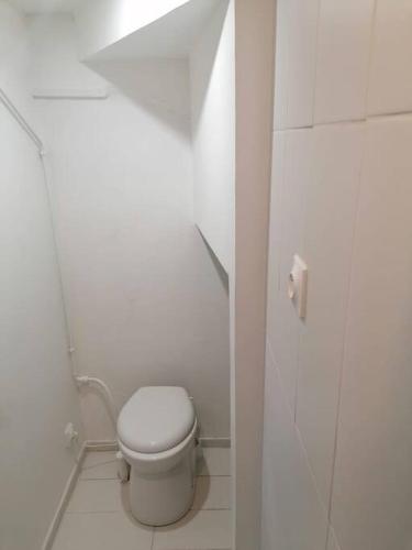 a white bathroom with a toilet in a stall at Superbe logement(C) avec Parking Gratuit sur place in Drancy