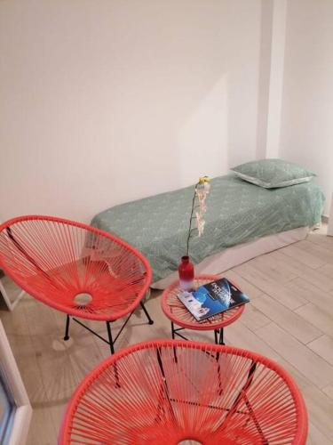 a room with three red chairs and a couch at Superbe logement(C) avec Parking Gratuit sur place in Drancy
