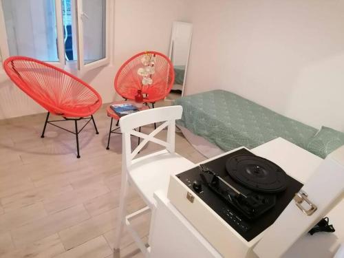 a living room with a stove and red chairs at Superbe logement(C) avec Parking Gratuit sur place in Drancy
