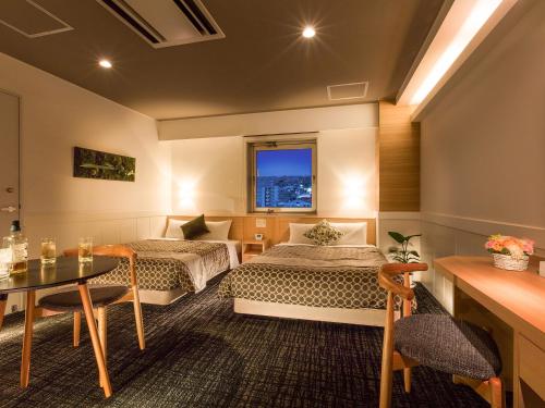 a hotel room with two beds and a table at Tokai City Hotel in Tokai