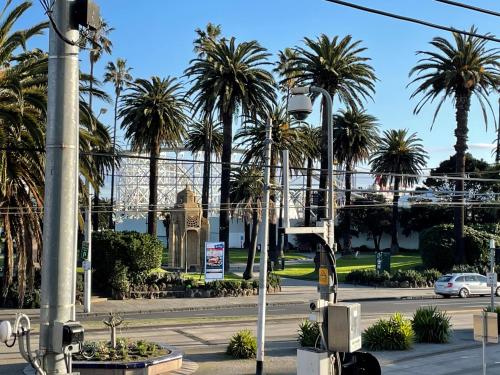 a street with palm trees and a building at Heart of St Kilda in Melbourne