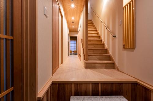un pasillo de una casa con suelo de madera y escaleras en Rinn Tsukinowa, en Kioto