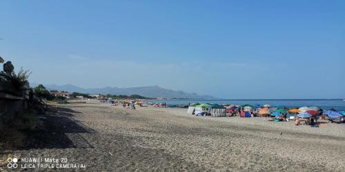 a group of people on a beach with umbrellas at Sea Garden, fronte mare con piscina in Mascali