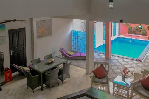 a living room with a pool and a table and chairs at 5 Bedroom Holiday Villa - Kuta Regency B8 in Kuta