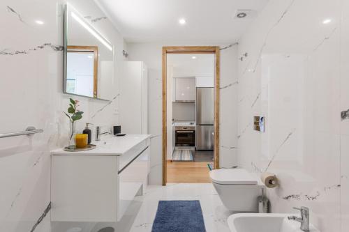 een witte badkamer met een wastafel en een toilet bij JOIVY Bright Flat, Quiet Area in Porto