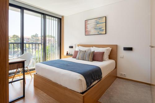 a bedroom with a bed and a desk and a window at ALTIDO Bright Flat, Quiet Area in Porto