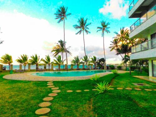 a resort yard with a swimming pool and palm trees at SWEET BREEZE HOMES in Mombasa