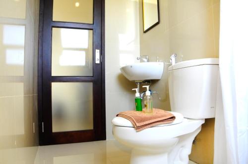 Un baño con inodoro, lavabo y puerta. en The Hill Ungasan, en Uluwatu